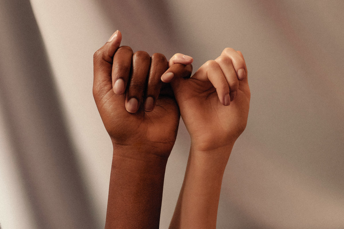 Two hands linking little fingers in a pinky promise